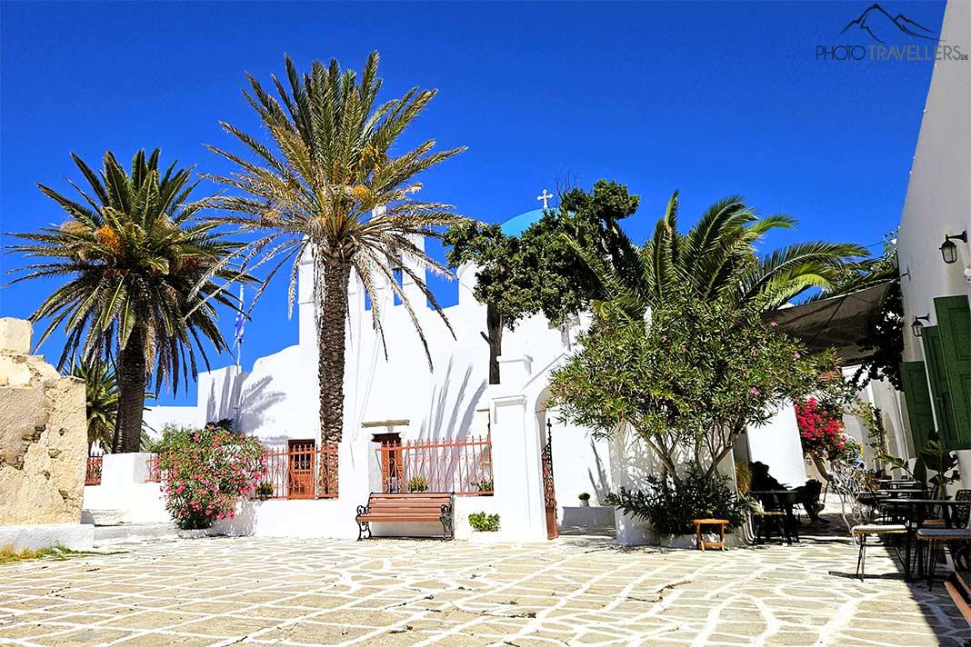 La blanca iglesia del pueblo de Kastro está rodeada de palmeras y árboles