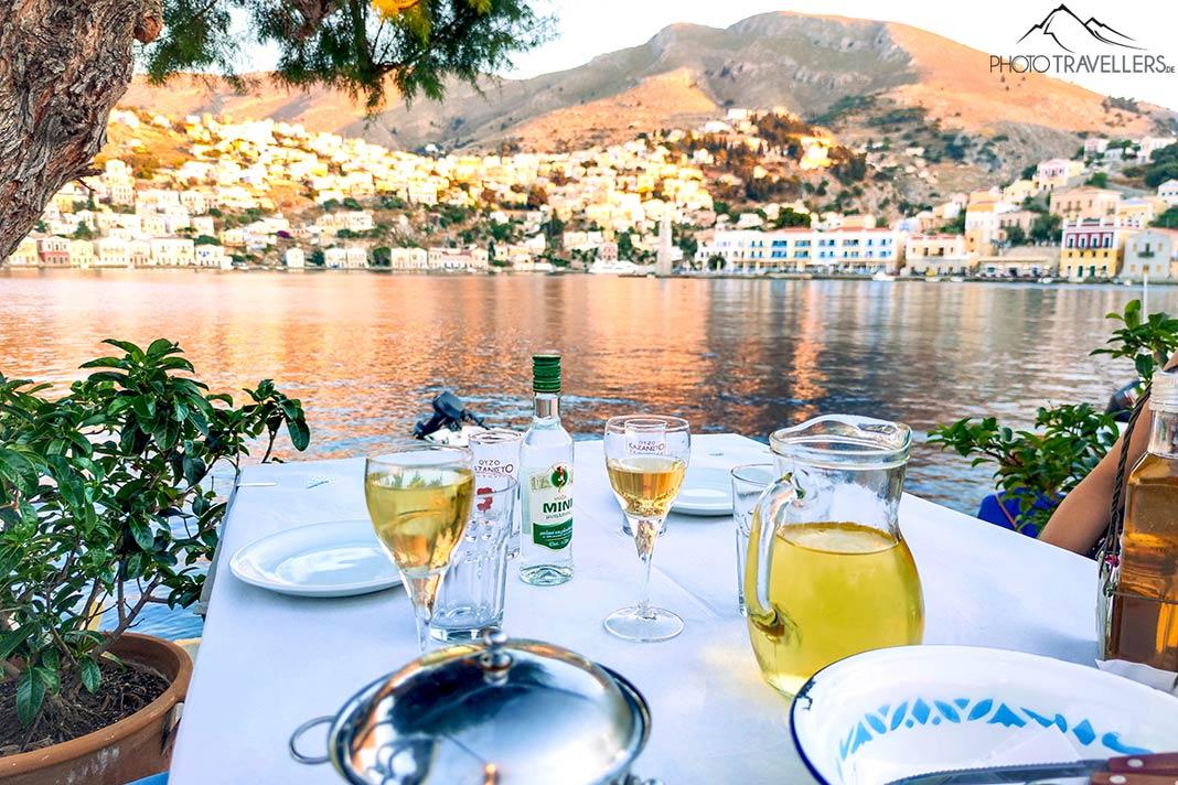 Table dressée avec des verres à vin au bord de la baie de Symi