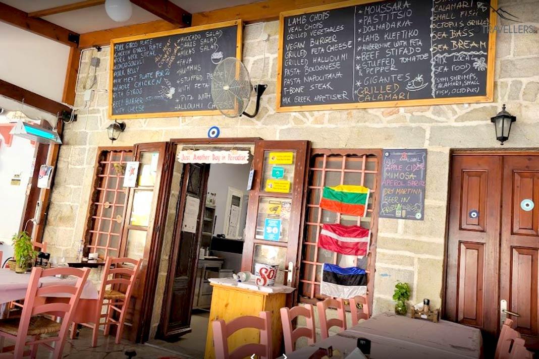 Porte d'entrée et tables d'une taverne avec des tableaux de plats au mur