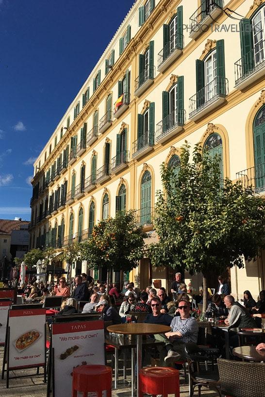 Des gens assis au soleil dans les cafés de la Plaza de la Merced à Malaga