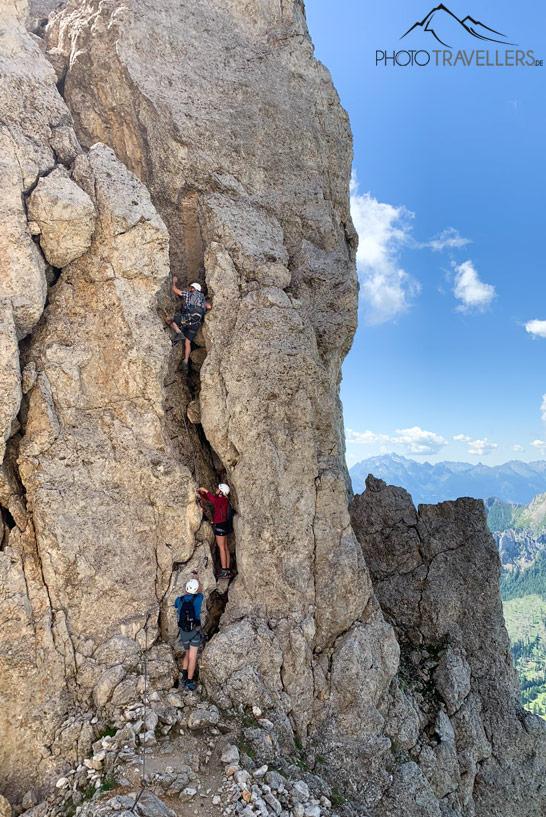 Escaladores suben por una grieta en el klettersteig Masaré