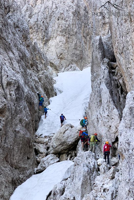 Escalador en un campo de nieve en el klettersteig Santnerpass