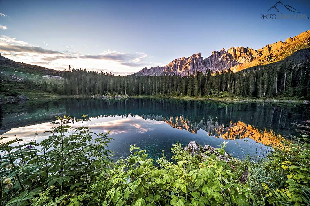 Le lac de Carezza au crépuscule avec les montagnes illuminées autour