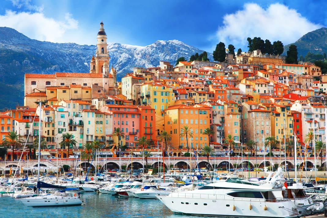 As casas coloridas da cidade francesa de Menton com as montanhas ao fundo