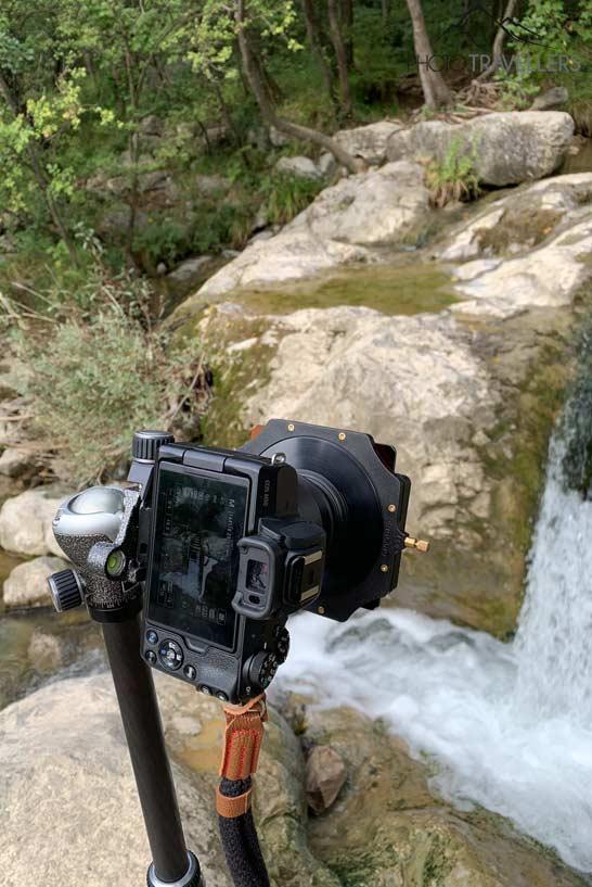 Un Canon EOS M50 sur un trépied avec un filtre gris devant une cascade