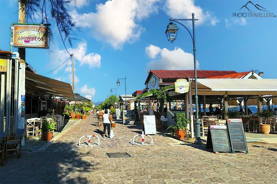 Des gens passent devant les tavernes sur la promenade de Skala Kallonis