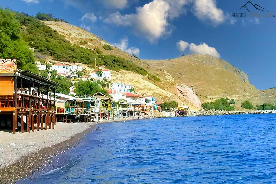 Dans la baie de Skala Eressos, entourée de collines, s'alignent des maisons sur pilotis en bois