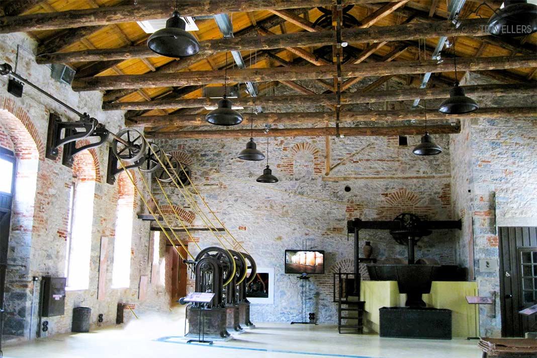 De hauts plafonds en bois et des presses historiques sont visibles dans le musée de l'huile d'olive de Lesbos