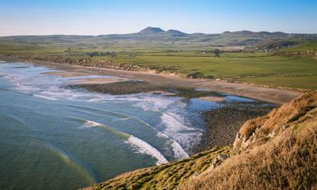A beautiful spring evening, with crashing waves on Porth Neigwl beach (Hell’s Mouth), with views over towards Mynytho and Garn Fadryn, Wales, UKR72627 A beautiful spring evening, with crashing waves on Porth Neigwl beach (Hell’s Mouth), with views over towards Mynytho and Garn Fadryn, Wales, UK