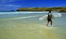 Surfer on the beach at Polzeath in north Cornwall, England