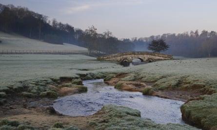 View of arched bridge over beck flowing through parkland at dawn, Hovingham Park, Hovingham, North Yorkshire, England, FebruaryE290P1 View of arched bridge over beck flowing through parkland at dawn, Hovingham Park, Hovingham, North Yorkshire, England, February